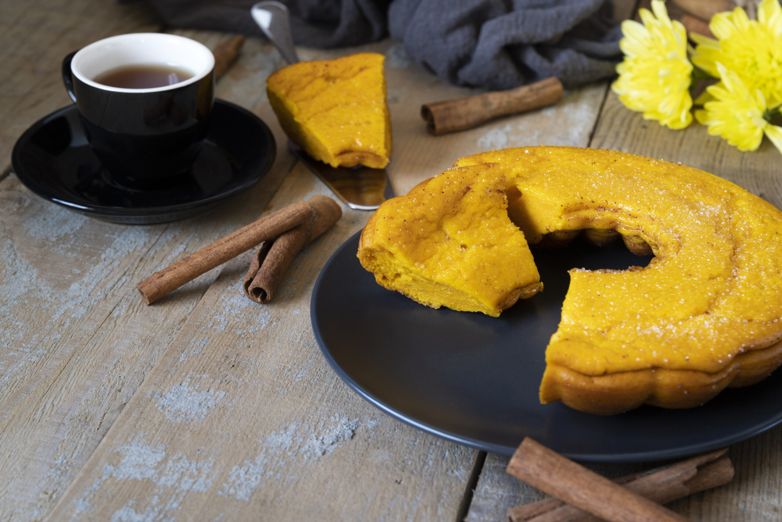 Bolo de fubá simples e rápido acompanhado de café, decorado com canela em pau.