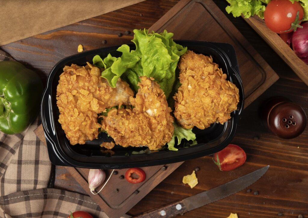 Frango empanado feito com air fryer com saldas ao redor em uma mesa rústica