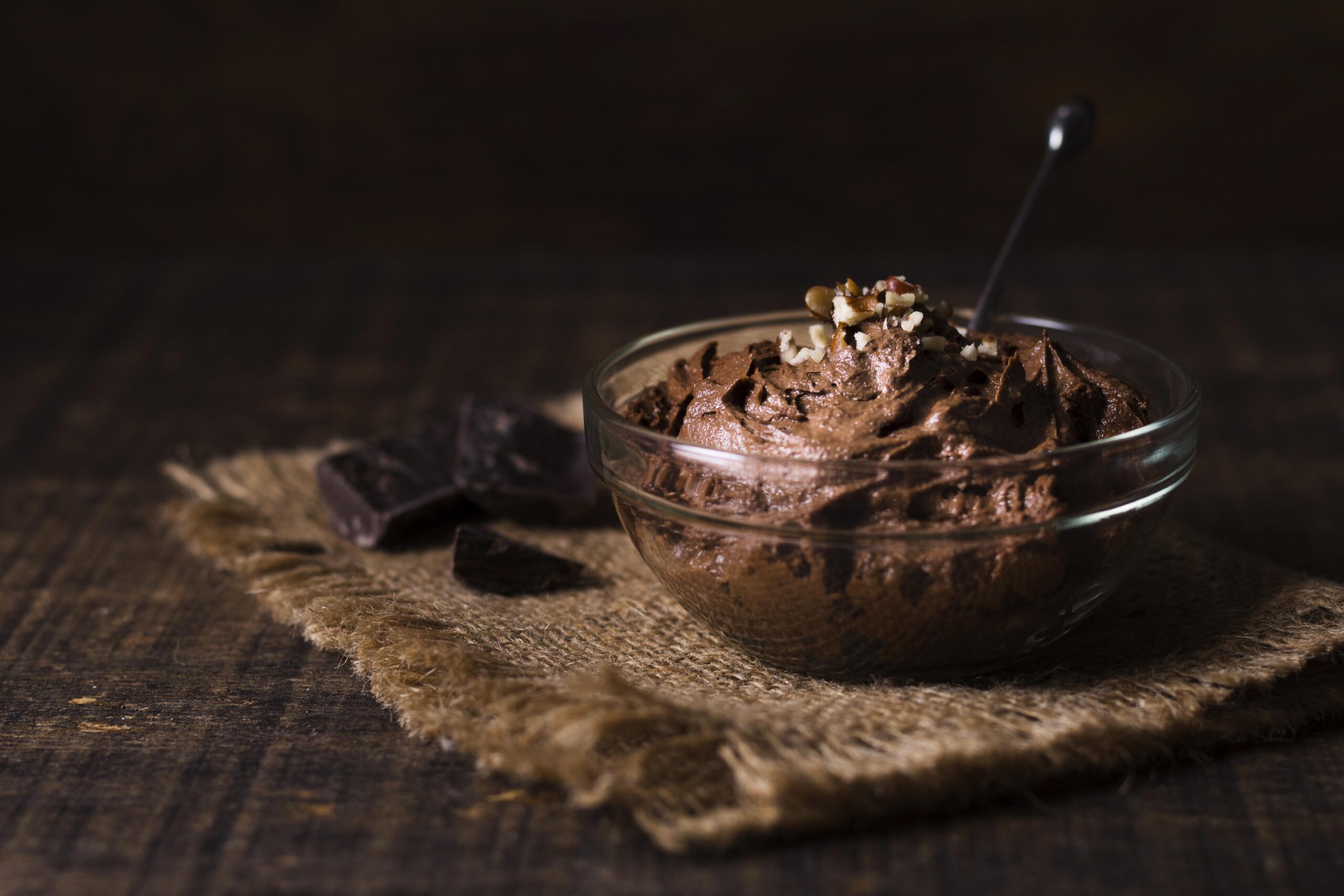 Mousse de chocolate sem açúcar em uma tigela de vidro, decorada com castanhas, ideal para diabéticos.