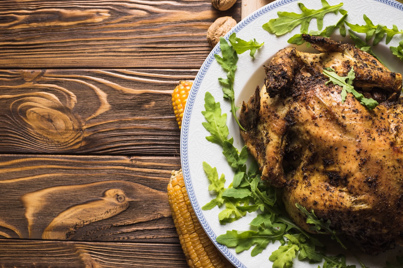 Frango grelhado suculento com ervas, servido em um prato decorado com folhas de rúcula, ideal para uma refeição saudável e saborosa.
