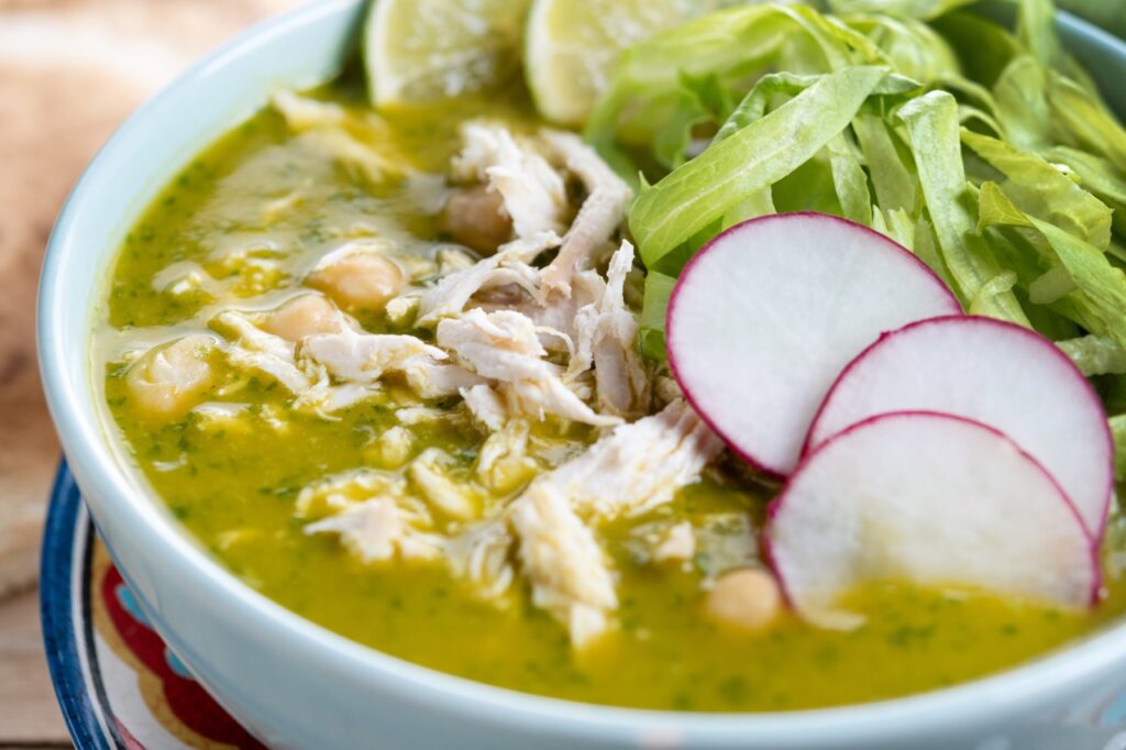 Sopa saudável de frango desfiado, com grão-de-bico, rabanete fatiado, alface e limão. Um prato leve e nutritivo para dias frios.