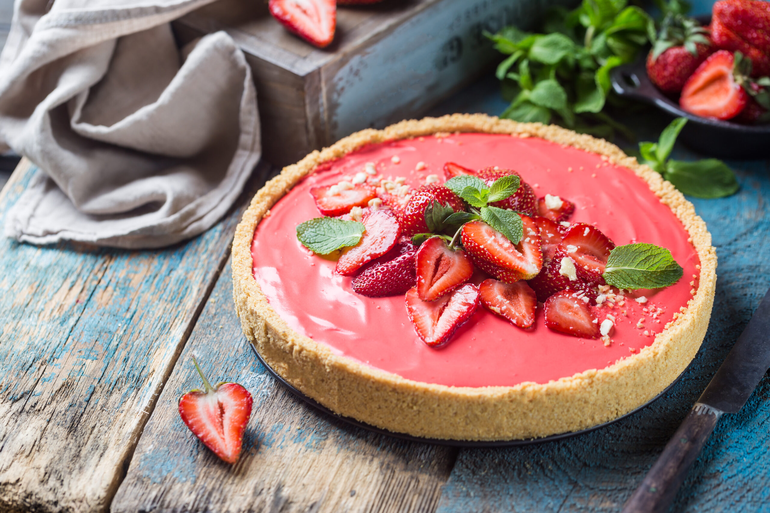 Torta de morango low carb sem açúcar com cobertura de morangos frescos e folhas de hortelã.