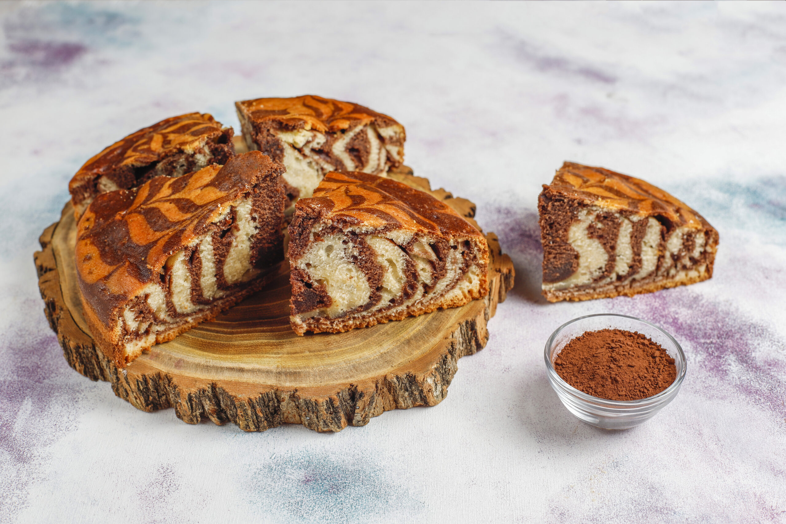 Fatias de bolo mármore de chocolate e baunilha sobre uma tábua de madeira.