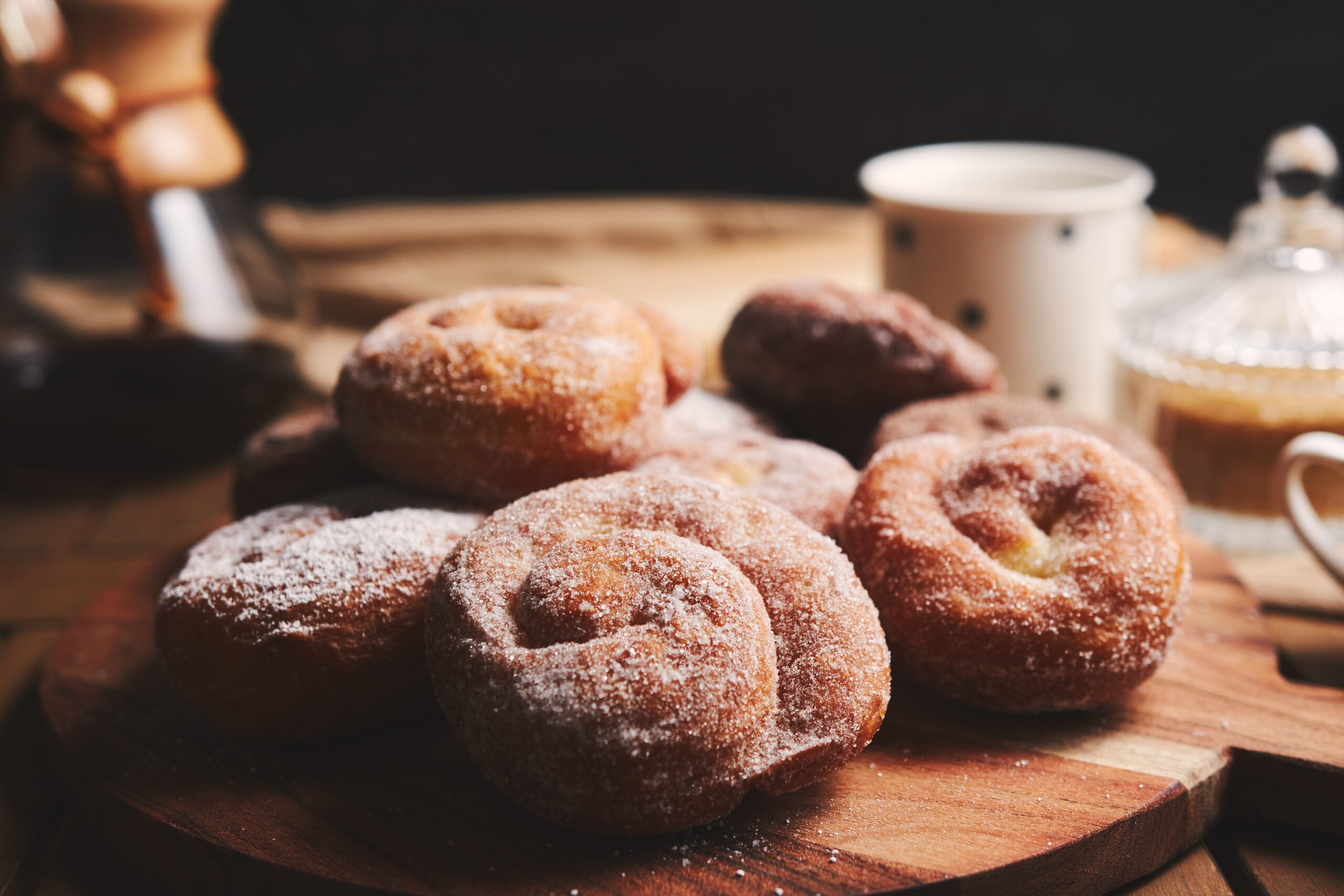 Donuts low carb de canela servidos em uma mesa rústica, cobertos com adoçante e polvilhados com canela.