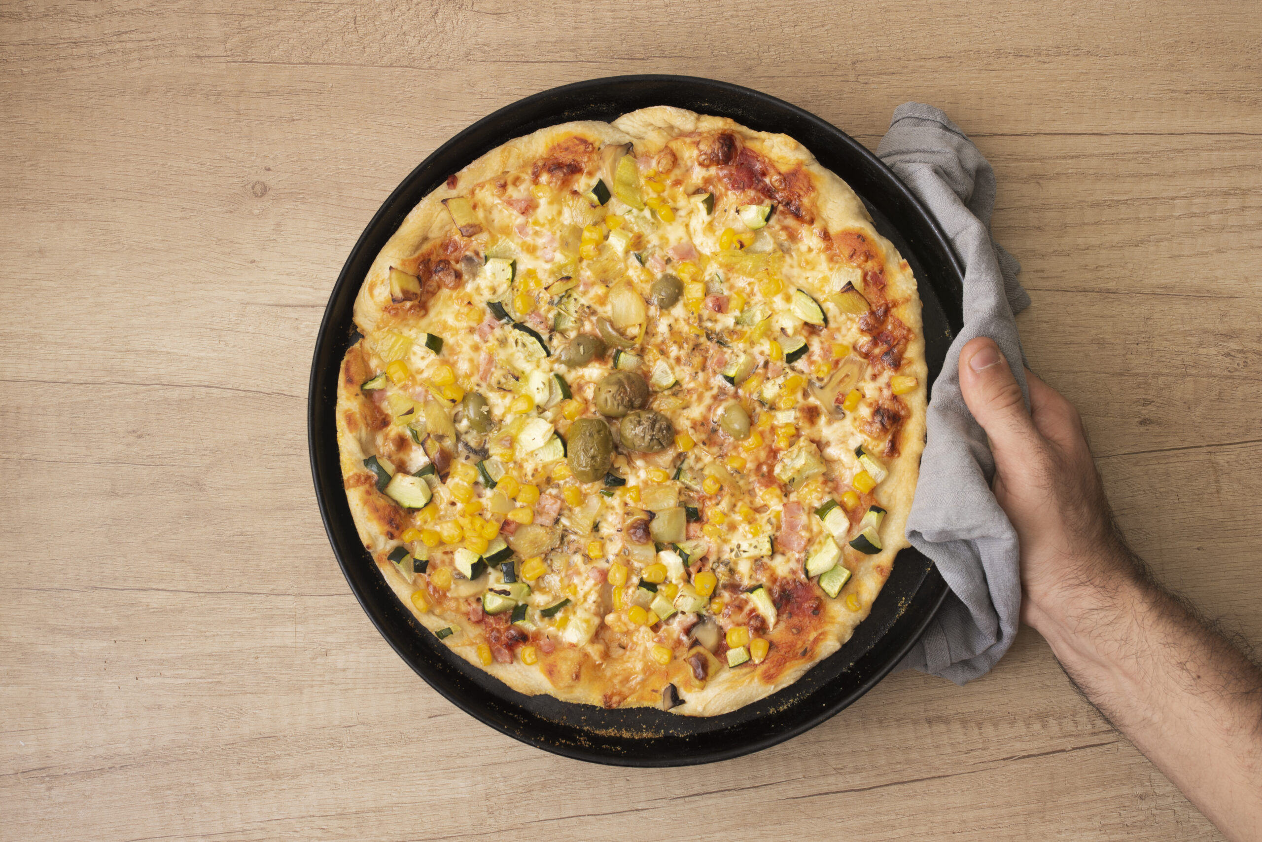Pizza fit com massa de whey e aveia com recheio de vegetais e azeitonas.