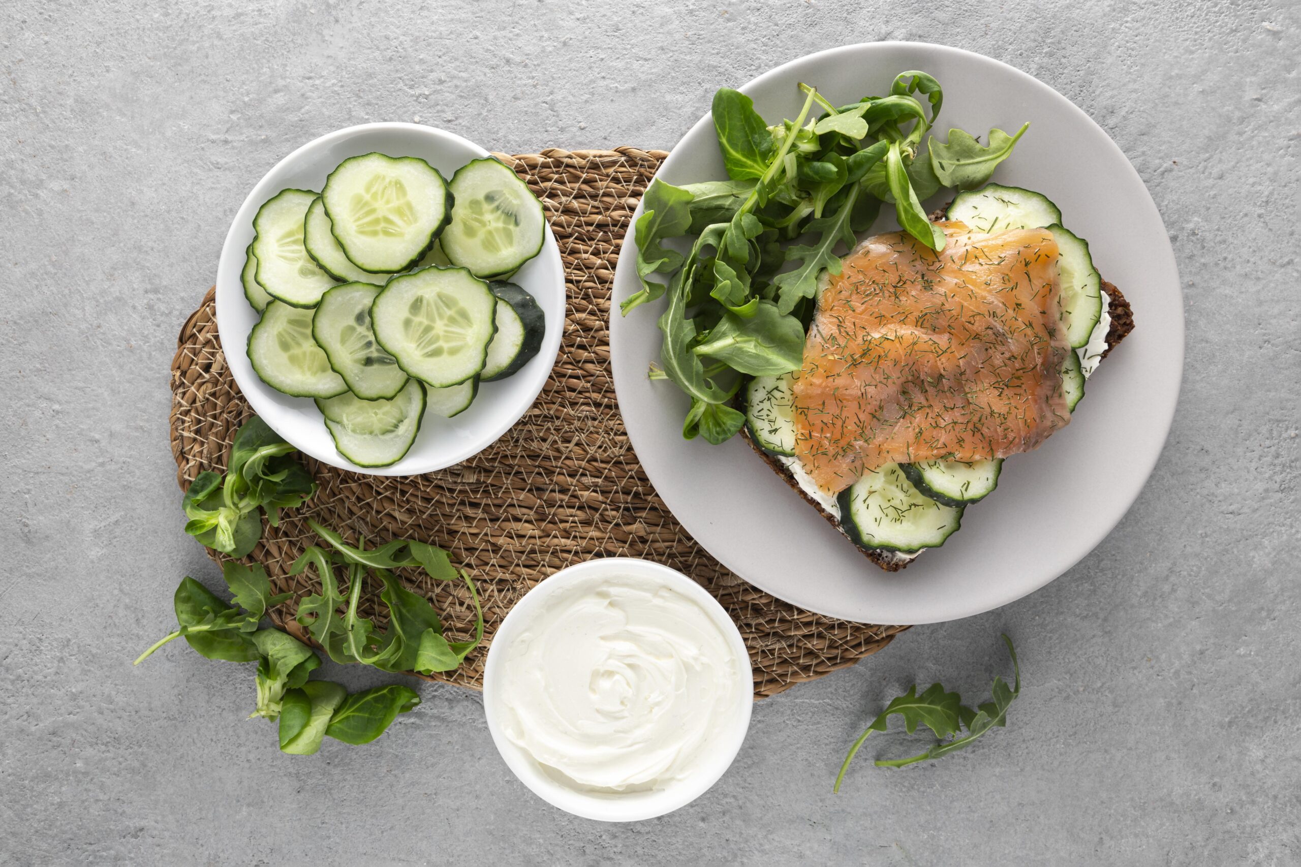 Salada de frango com molho de iogurte, hortelã, pepino e rúcula servida em prato claro.
